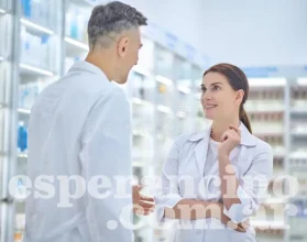 hombre-y-mujer-hablando-en-farmacia-del-personal-jóvenes-adultos-hombres-mujeres-con-abrigos-blancos-parados-uno-frente-al-otro-234085601