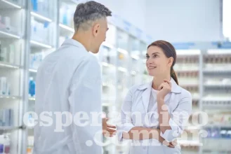 hombre-y-mujer-hablando-en-farmacia-del-personal-jóvenes-adultos-hombres-mujeres-con-abrigos-blancos-parados-uno-frente-al-otro-234085601